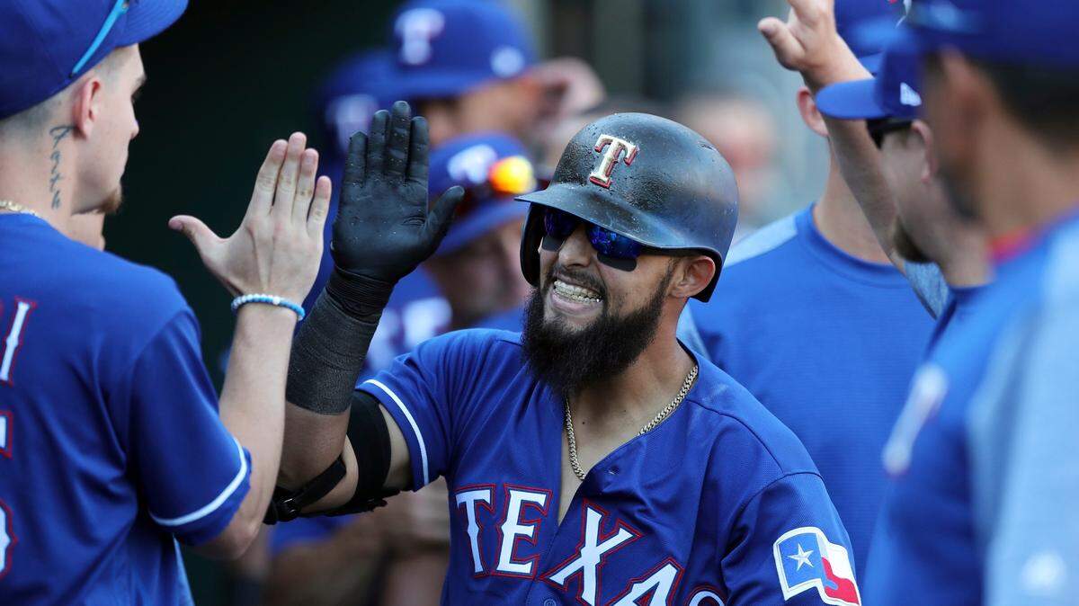 Rougned Odor is greeted in the dugout after his solo home run in the sixth inning of the Rangers' 7-1 loss to the Tigers Saturday afternoon at Comerica Park.