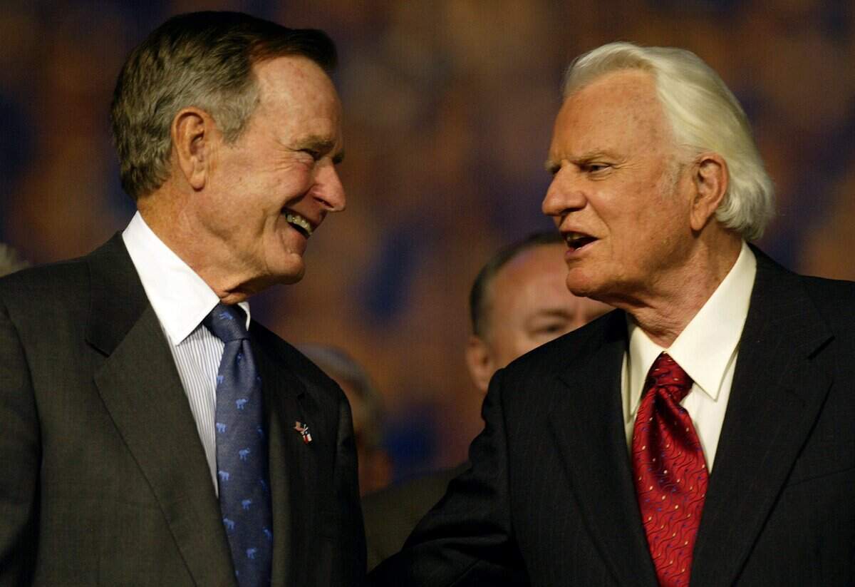 Former U.S. President George Bush (L) and the Rev. Billy Graham talk during the first of a four-day revival meeting October 17, 2002  at Texas Stadium in Irving, Texas.