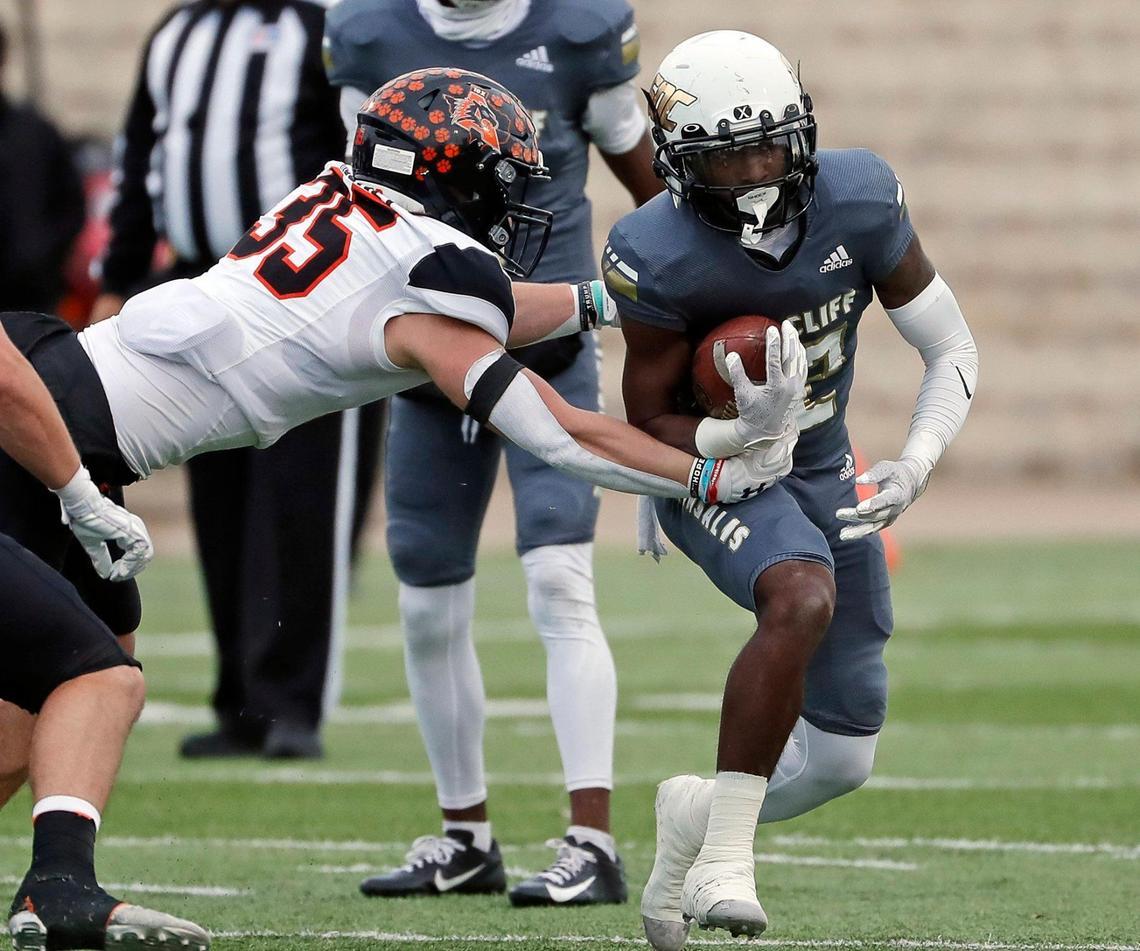 Aledo linebacker Cap Mooney (35) attempts to corral South Oak Cliff running back Ke’Undra Hollywood (12) in the backfield during a high school Class 5A Division 2 Regional football game at Newsom Stadium in Mansfield, Texas, Friday Nov. 26, 2021. South Oak Cliff defeatd Aledo 33-28 to move on the the State Quarter Finals. (Special to the Star-Telegram Bob Booth)