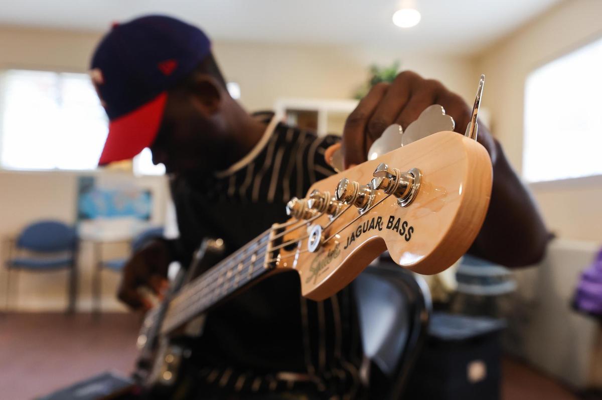 Abale Kalonga tunes his base before practice with the during Refugee Music Collaborative Saturday, Dec. 4, 2021, in Fort Worth.