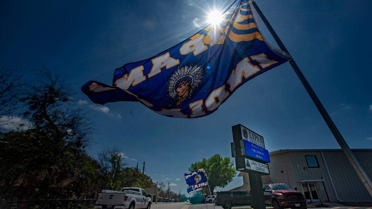 Flags for the Lipan Indians baseball team flutter in the breeze along Kickapoo Street on game day. This sleepy town of less than 500 people is intricately tied to the school. Photo taken Friday, March 24, 2023.