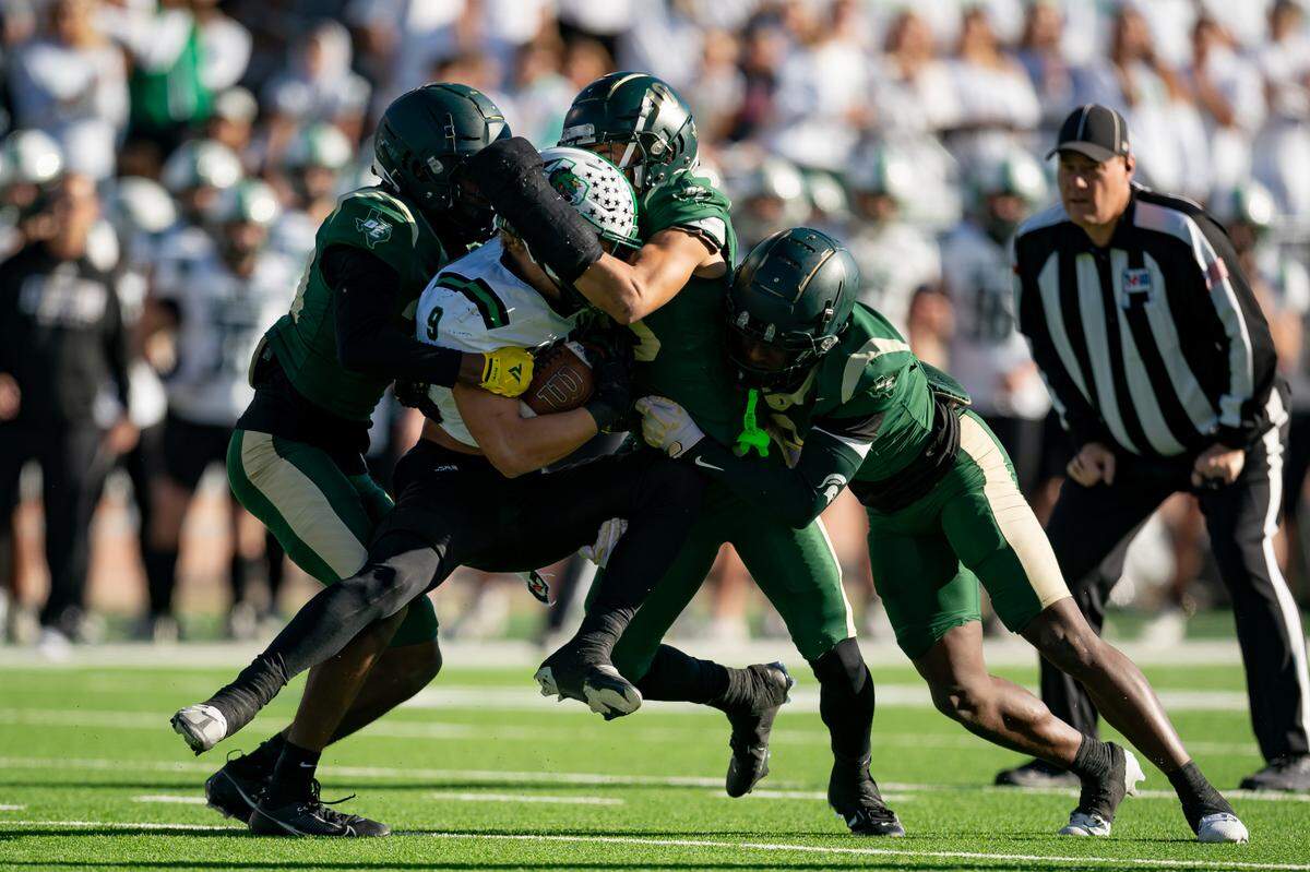 Southlake Carroll running back Riley Wormley is tackled by multiple DeSoto defenders in a state semifinal game in Allen, Texas on Dec. 9, 2023.
