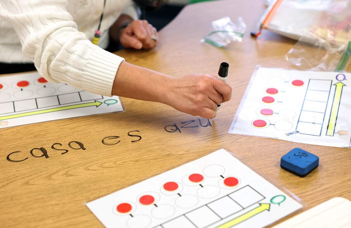 Kindergarten teacher Arselia Espinoza, right, works with students on identifying the words in a sentence during class at Caesar Chaves Elementary on Tuesday, Feb. 3, 2026, in Fort Worth.