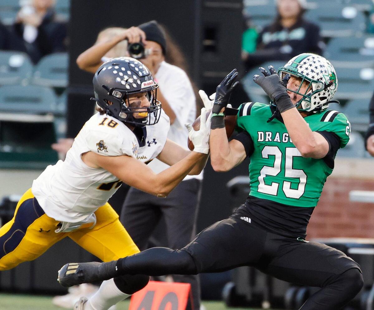 Highland Park wide receiver Charles Schneider (18) catches a pass defended by Carroll defensive back Sam Fuller (25) in the first half of a UIL Conference 6A Division 2 region football playoff game at Choctaw Stadium in Arlington, Texas, Friday, Nov. 24, 2023.