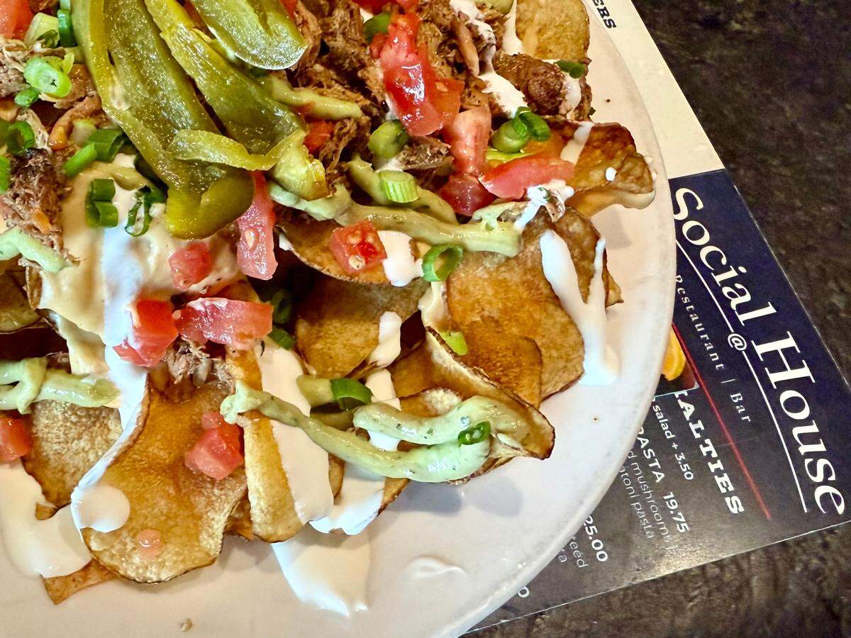 The “Irish nachos” at Social House restaurants in Fort Worth and Arlington are a huge helping of house-cut russet chips topped with pulled pork, pickled jalapeno strips and cheese sauce, but also with avocado mousse and creme fraiche, as seen March 9, 2025.