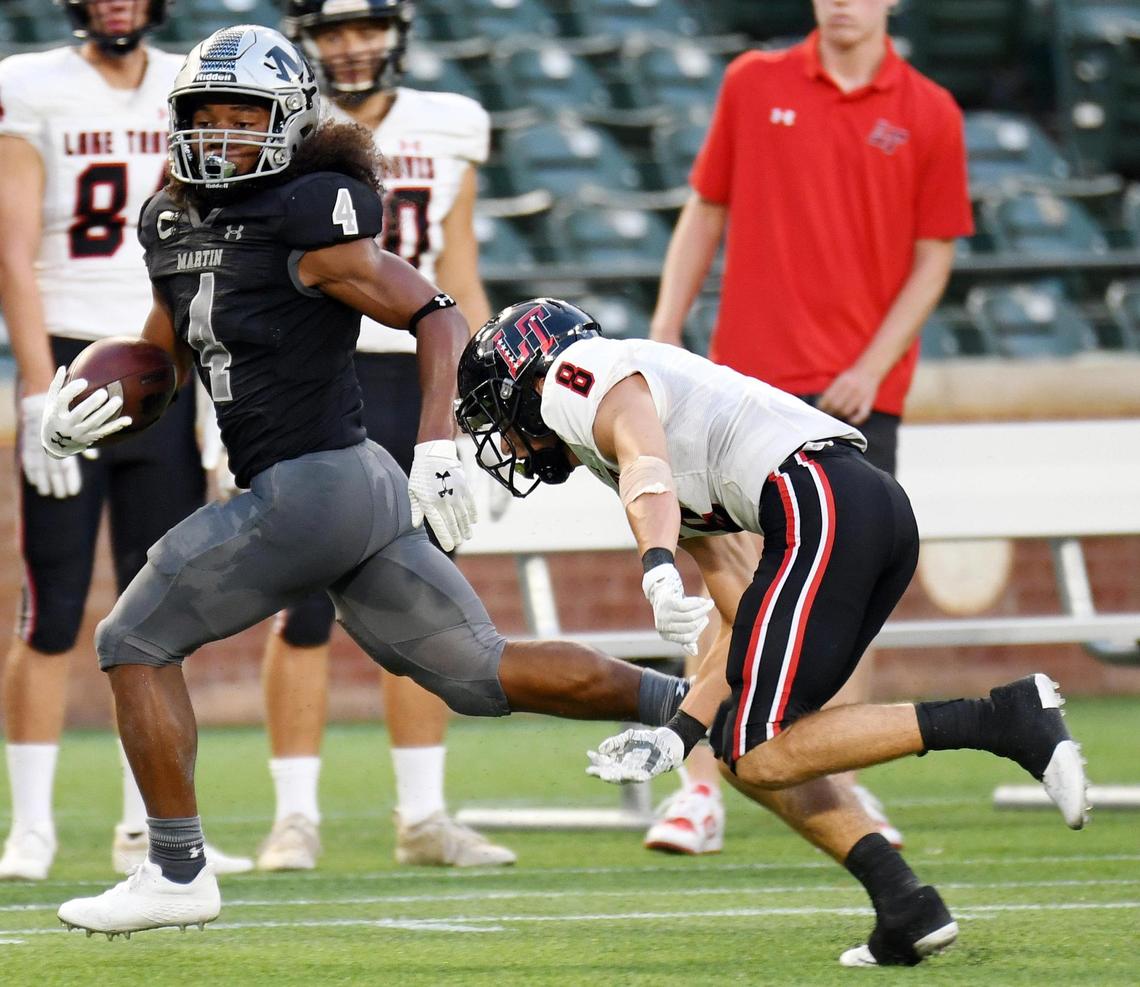 Arlington Martin’s Zaire Barrow, left escapes Lake Travis’s Lucas Casey-Moore to run 64 yards and a touchdown.