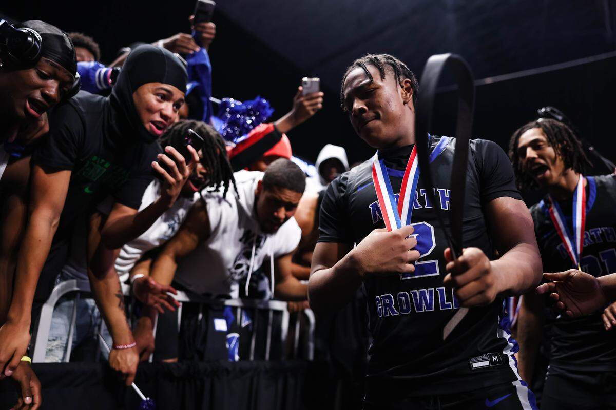 North Crowley guard Kameron Price (2) holds a belt as fellow students celebrate after winning the Class 6A Division I state championship game against San Antonio Brennan on Saturday at the Alamodome in San Antonio.