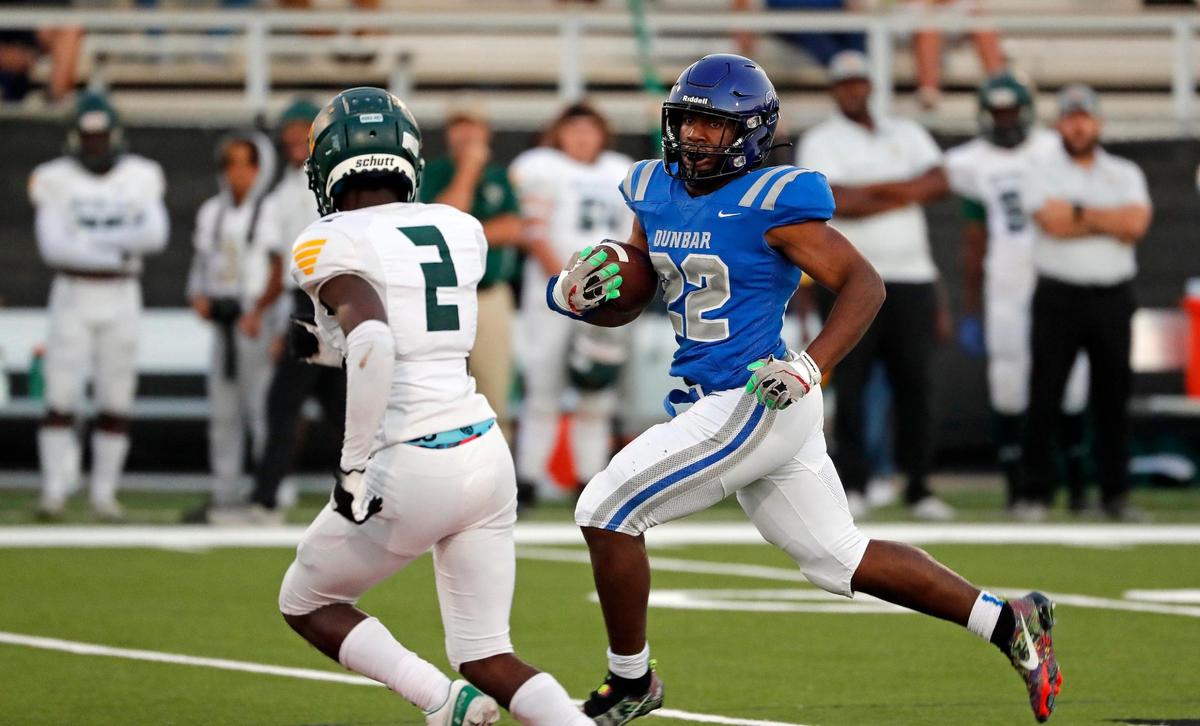 Western Hills defensive back Cam Brown (2) zeros in on Dunbar running back Murry Moore (22) in the first half of a 6-4A division 1 high school football game at Scarborough-Handley Field in Fort Worth Texas, Thursday, Sept. 29, 2022. Dunbar led Western Hills 24-13 at the half. (Special to the Star-Telegram Bob Booth)