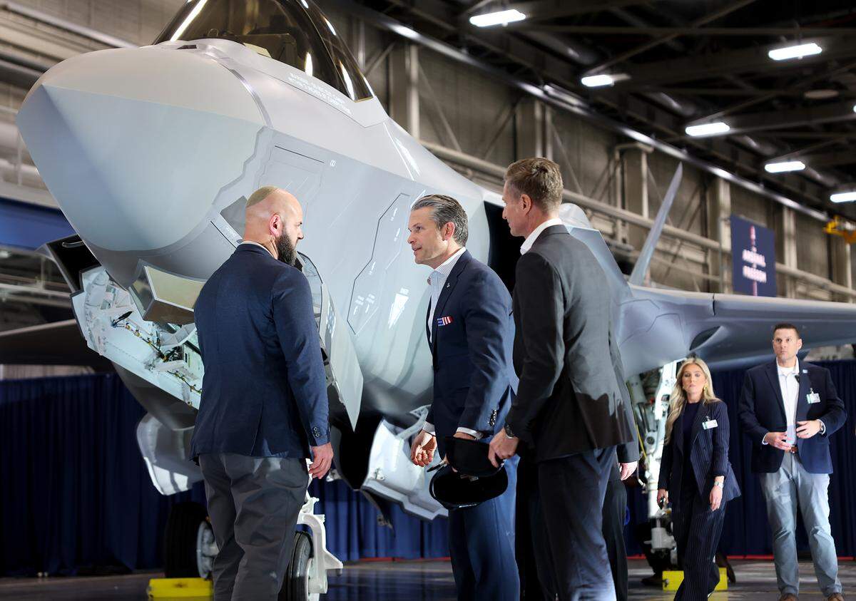  Defense Secretary Pete Hegseth, center, talks with Lockheed Martin employees before signing a F-35 Lighting II fighter jet at Lockheed Martin’s Fort Worth facility on Monday, Jan. 12, 2026. Hegseth visited the facility as part of his  “Arsenal of Freedom” industry tour. 