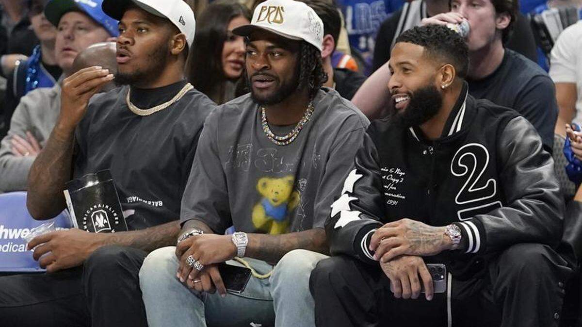 Odell Beckham Jr., right, sits with Dallas Cowboys Micah Parsons, left, and Trevon Diggs during the first half of an NBA basketball game between the Phoenix Suns and Dallas Mavericks in Dallas, Monday, Dec. 5, 2022. (AP Photo/LM Otero)