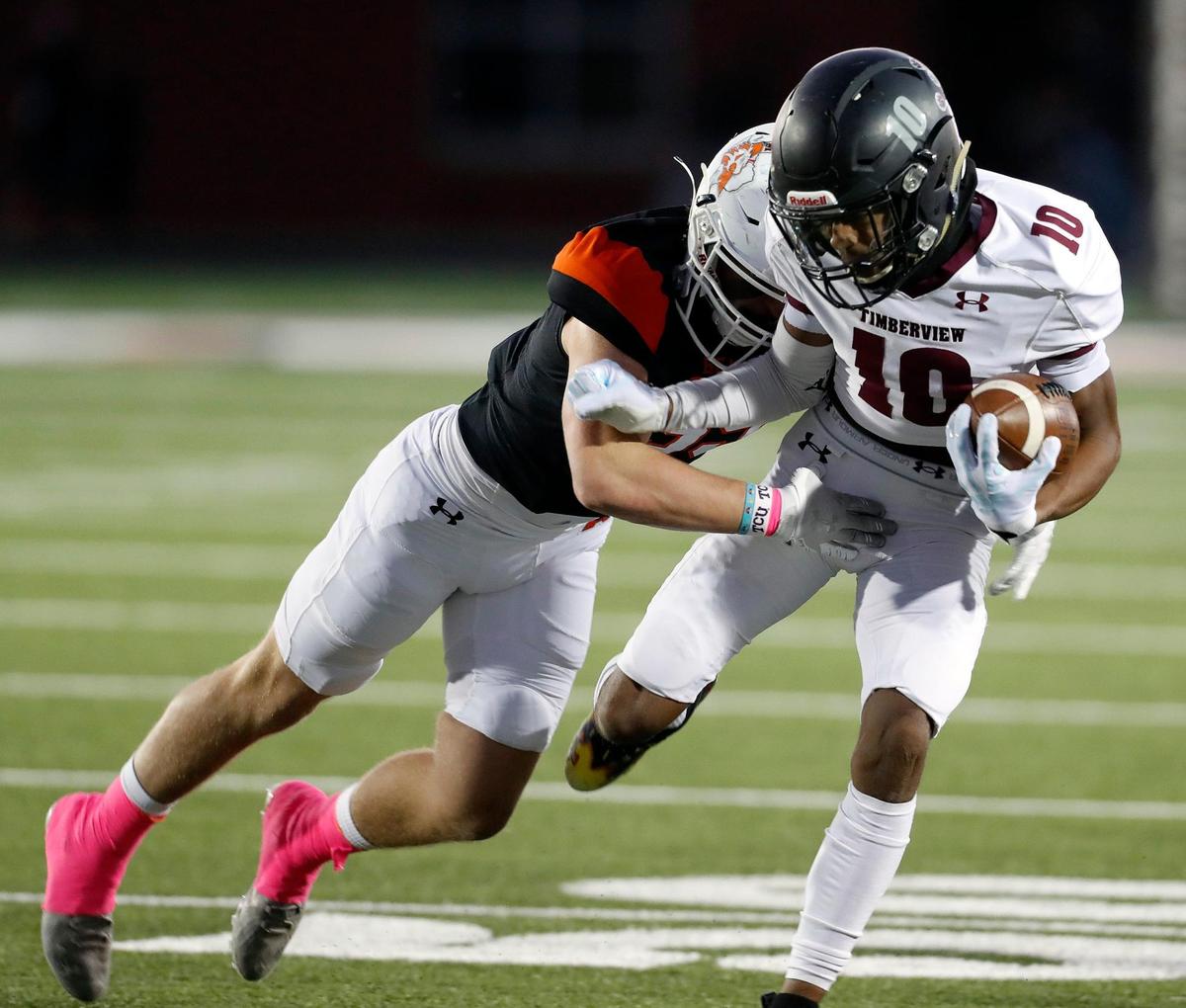 Timberview wide receiver Cemarion Chambliss (10) is brought down by an Aledo defender in a high school district 5-5A division 2 football game at Bearcat Stadium in Aledo, Texas, Friday Oct. 15, 2021. After a late second quarter Timberview touchdown the score was knotted at 14 at the half. (Special to the Star-Telegram Bob Booth)