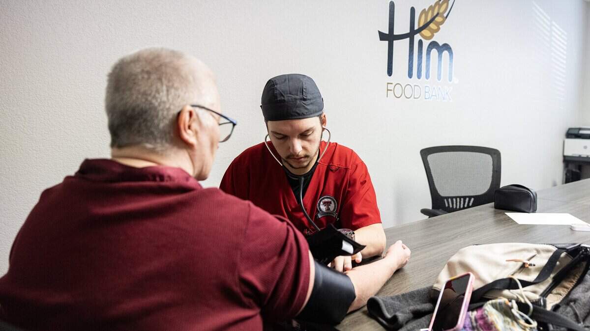 Nursing student Grayson Walker takes the blood pressure of Karen Gotchas part of the Wellness on Wheels program at Him Food Bank in Mansfield on Wednesday, Dec. 3, 2025.