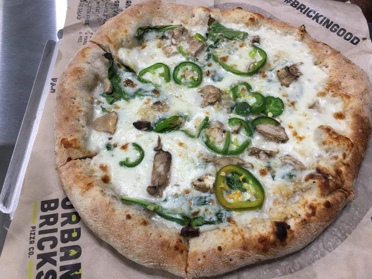 Urban Bricks’ White Mushroom pizza features a sprinkling of button mushrooms, spinach and roasted garlic atop a light, white sauce.
