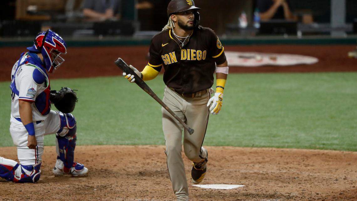Texas Rangers catcher Jose Trevino kneels by the plate as San Diego Padres’ Fernando Tatis Jr. watches the flight of his grand slam ball that came off a pitch from Rangers relief pitcher Juan Nicasio in the eighth inning of a baseball game in Arlington, Texas, Monday Aug. 17, 2020. The shot also scored Jurickson Profar, Josh Naylor and Trent Grisham. (AP Photo/Tony Gutierrez)
