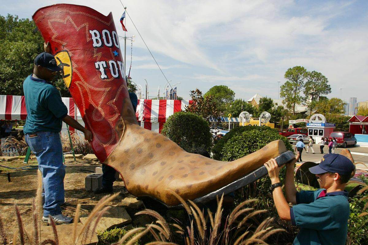 Sept. 22, 2003: The raising of Big Tex took place this morning on the grounds of The State Fair of Texas in Dallas. Amusements Inc. workers Eric Gassaway, left, and Nathan Williams lift the right boot.