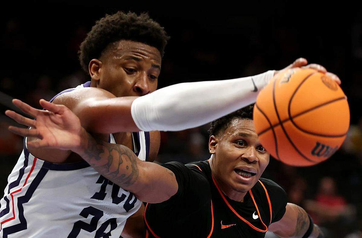 KANSAS CITY, MISSOURI - MARCH 11: Christian Coleman #4 of the Oklahoma State Cowboys and Xavier Edmonds #24 of the Texas Christian University Horned Frogs compete for a rebound during the second round game of the Men's 2026 Big 12 Tournament at T-Mobile Center on March 11, 2026 in Kansas City, Missouri. (Photo by Jamie Squire/Getty Images)