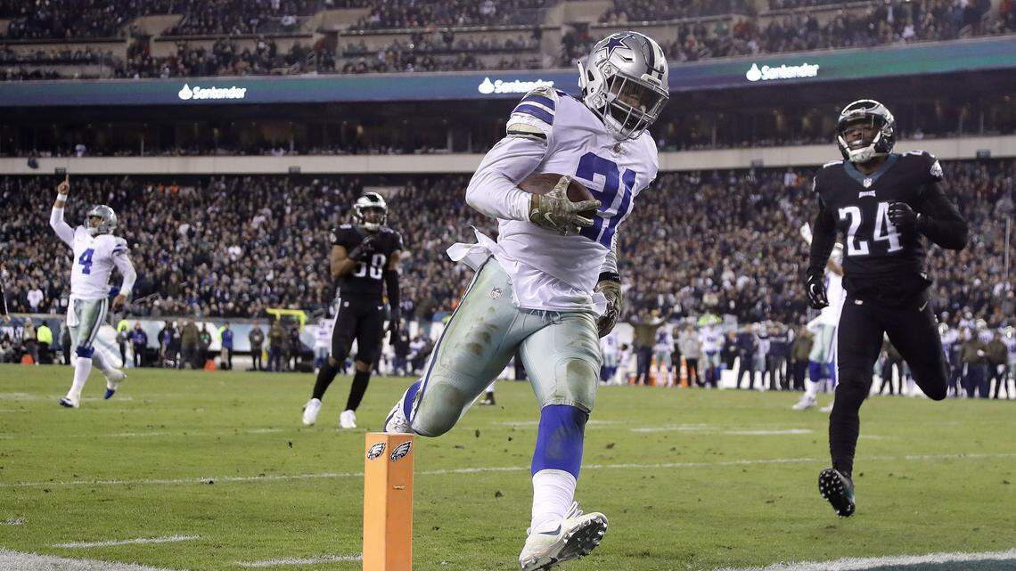Dallas Cowboys running back Ezekiel Elliott (21) scores on a touchdown pass from quarterback Dak Prescott (4) as Philadelphia Eagles free safety Corey Graham (24) tries to stop him during the second half of an NFL football game, Sunday, Nov. 11, 2018, in Philadelphia.