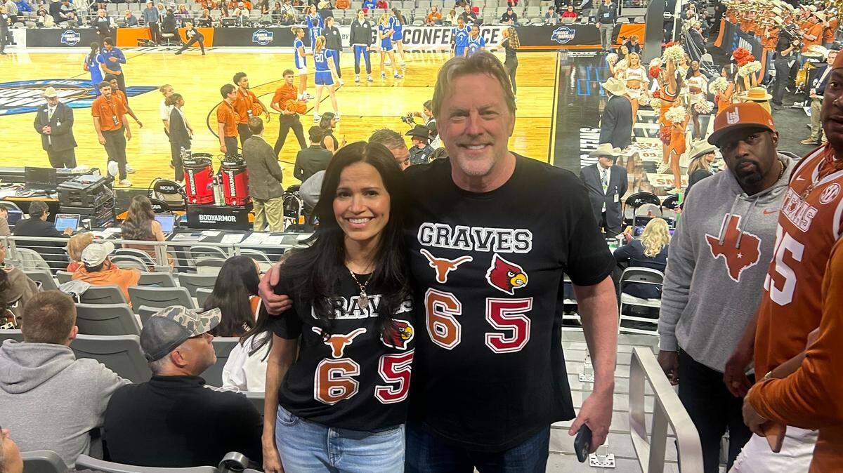 Nicole Graves (left) and John Graves (right) wearing a shirt representing their daughters Rebekah Graves, who plays for Louisville, and Sarah Graves, who plays for Texas.