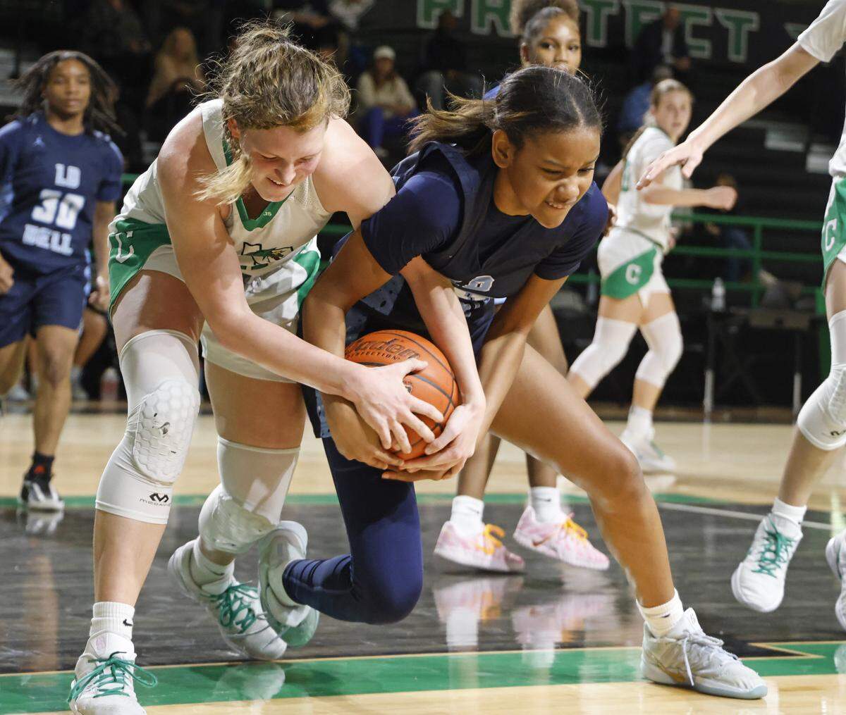 Southlake guard Payton Lee (21) and L.D. Bell guard Maddison Rhodes (10) tie up a loose ball during the second half of a UIL girls basketball game between L.D. Bell and Southlake Carroll at Southlake Senior High School in Southlake, Texas, Tuesday Feb. 03, 2026