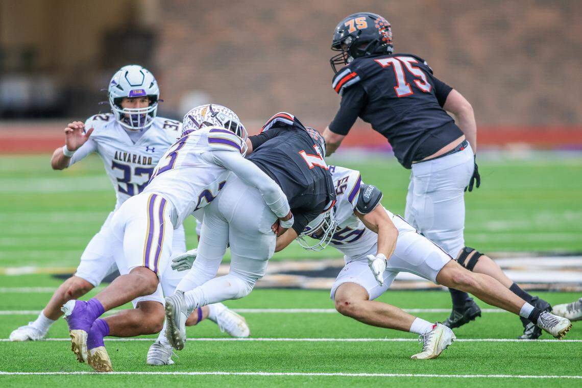 Alvarado defenders Zyon Brown (23) and Leland Hopson (55) sack Springtown quarterback Kaine Hill during a Class 4A Division I regional semifinal Friday, Nov. 28, 2025, at Knight Stadium at Eagle Mountain High School in Fort Worth.