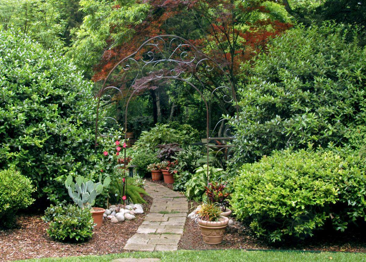 DIY concrete stones and rustic old garden arch are a decorative touch to this part of the Sperry gardens.