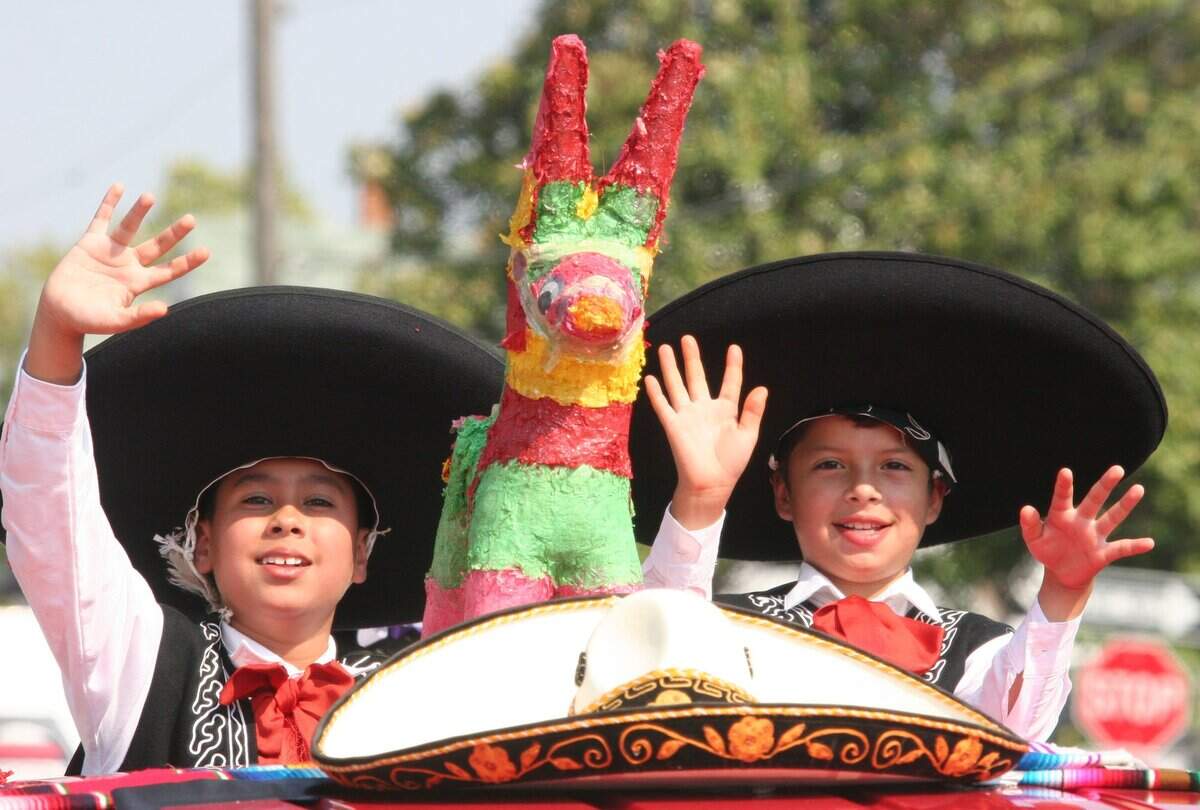 Sept. 10, 2005: Daniel Marquez, left, and Ivan Oropeza of Danza Cultural Fort Worth wave from a truck at the Mexican Independence Day parade in downtown Fort Worth.