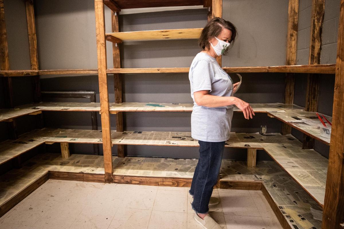 Sonia Belanger glues paper to shelves as construction continues at Dapper Cafe. The Awareness Project tackles food rescue and environmental conservation and includes a cafe, thrift store and food pantry.