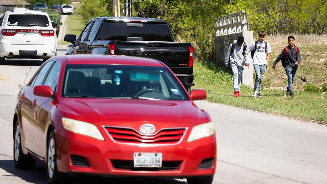 Students walk along the shoulder of Cromwell Marine Creek Road, one of the roads that will be improved if voters approve a $560 million bond proposal.