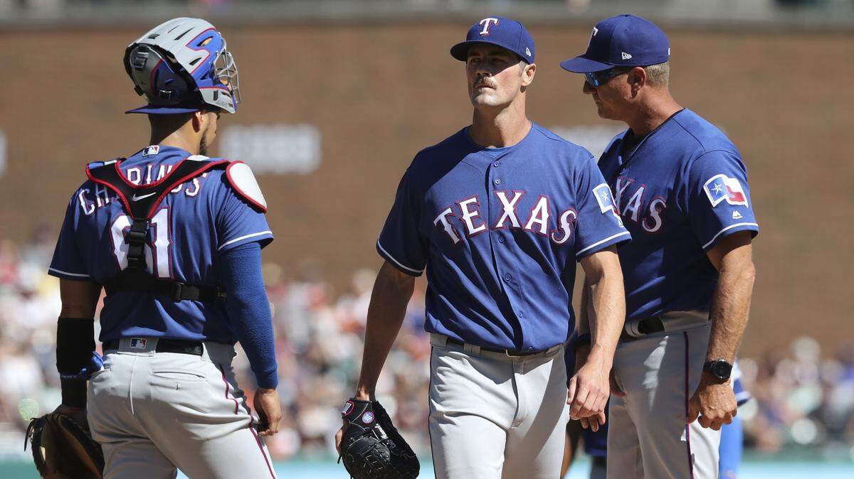 Rangers starting pitcher Cole Hamels, center, walks to the dugout after being relieved after just 2/3 of an inning in Saturday's loss to the Tigers. It ties Hamels' shortest outing of his career. He was charged with seven runs (four earned) on five hits and two walks.