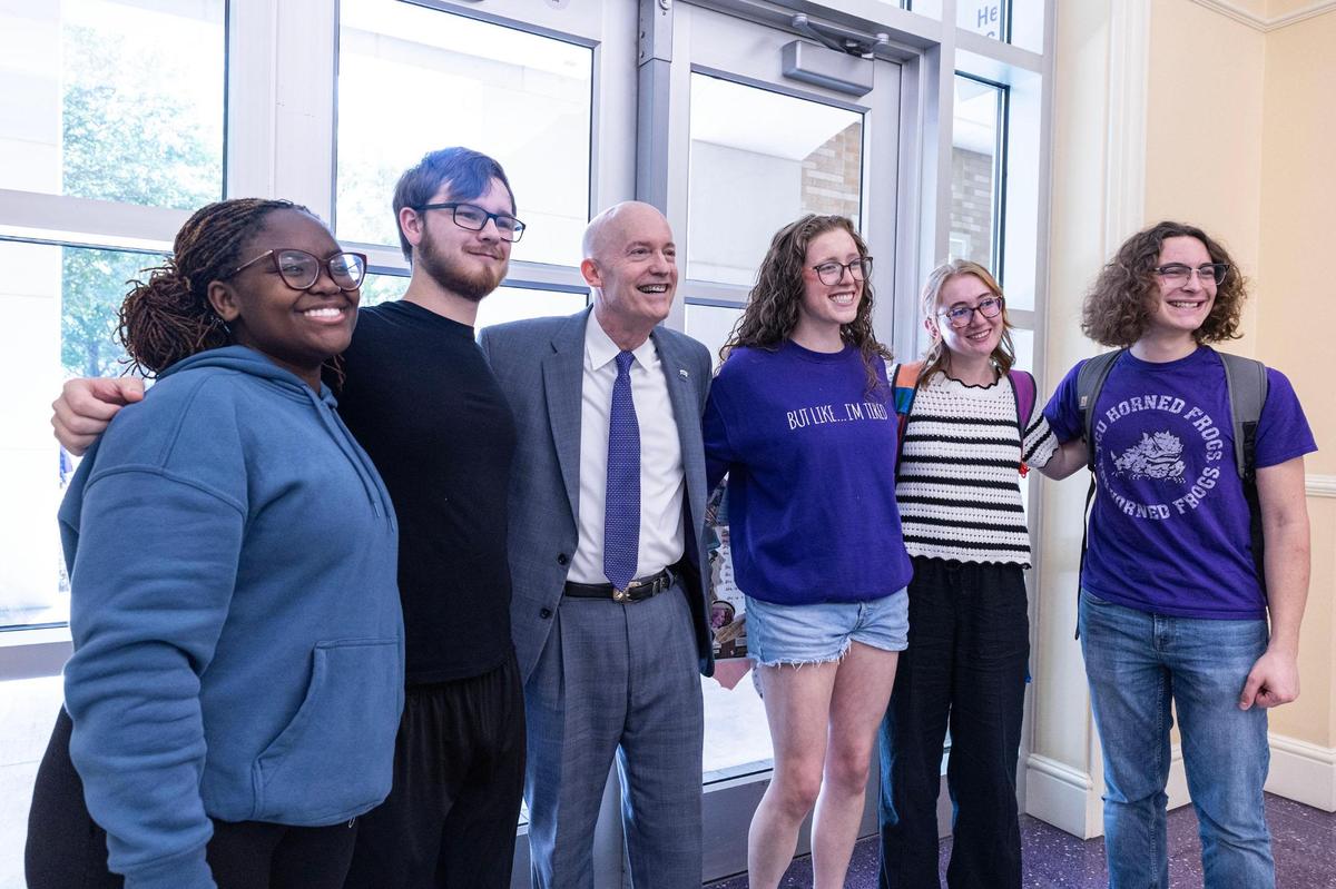 TCU Chancellor Victor J. Boschini Jr. takes a photo with students at Brown-Lupton University Union.