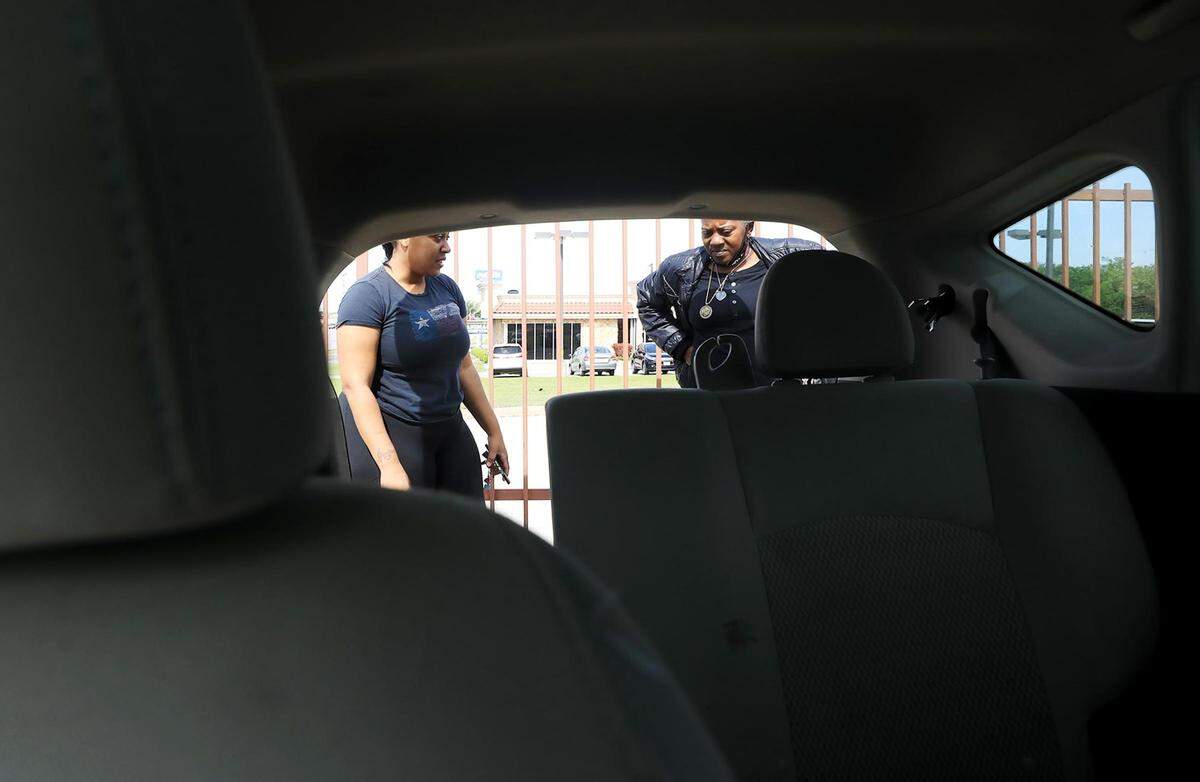 Jazmine Brooks, left, and her mother, BJ Fennell, look at a used 2014 Nissan Versa at Owl Own It Auto Sales on Tuesday, April 19, 2022, in Fort Worth.