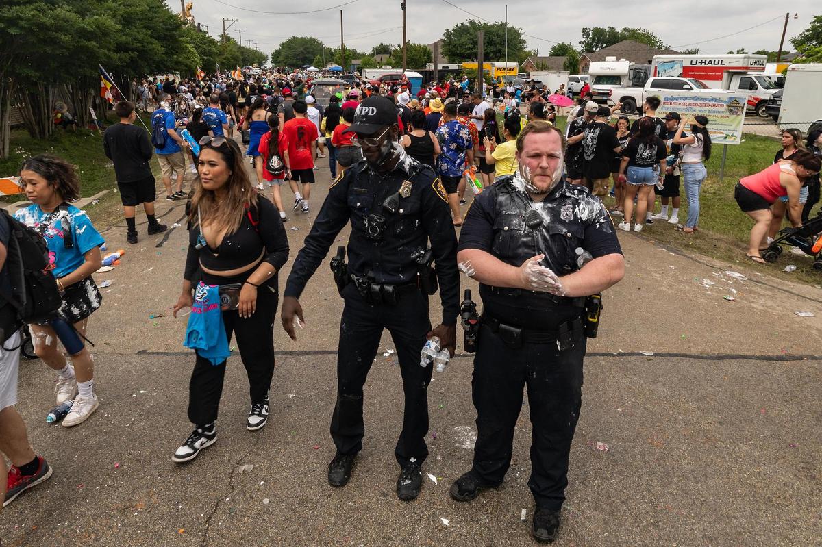 Fort Worth Police Department police officers become covered in shaving cream with the parade attendees during the Lao New Year parade on the third day of the Lao New Year festival at Wat Lao Thepnimith Temple in Saginaw on Sunday, April 27, 2025.