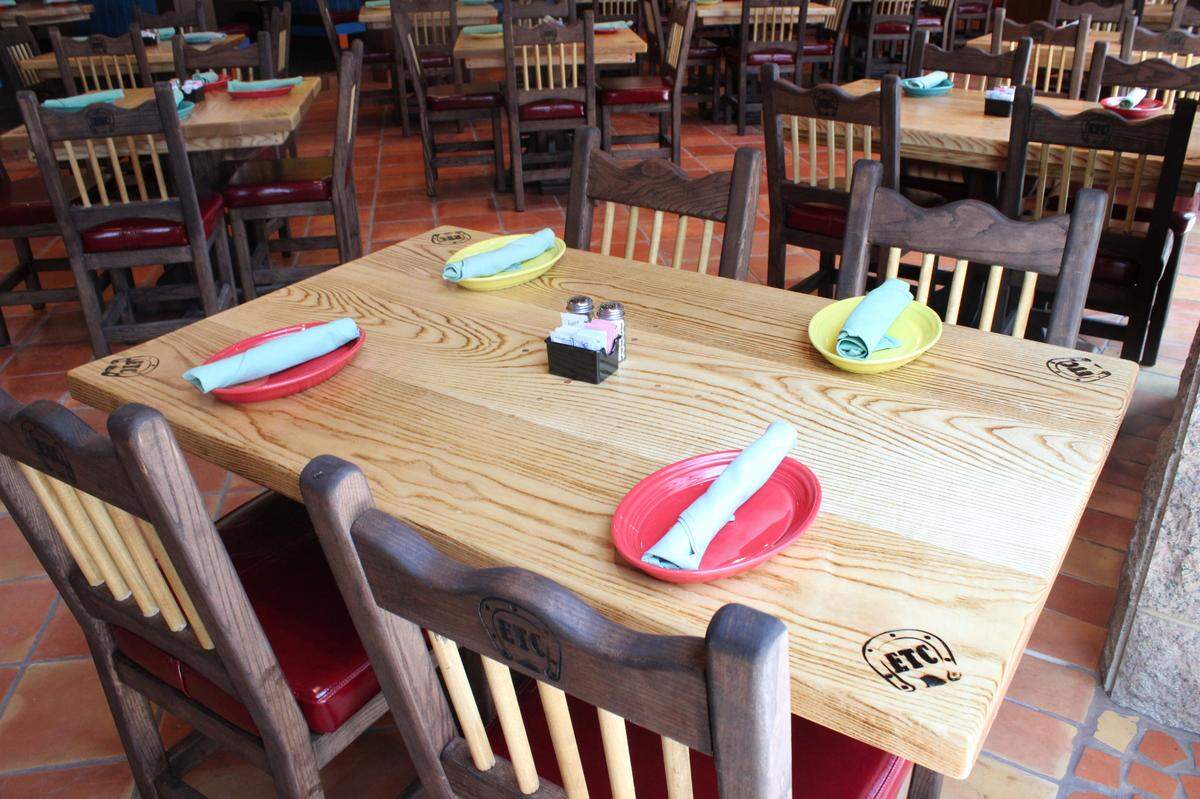El Tiempo Cantina makes all their dining tables from scratch with hardwood. El Tiempo is branded into the four corners.