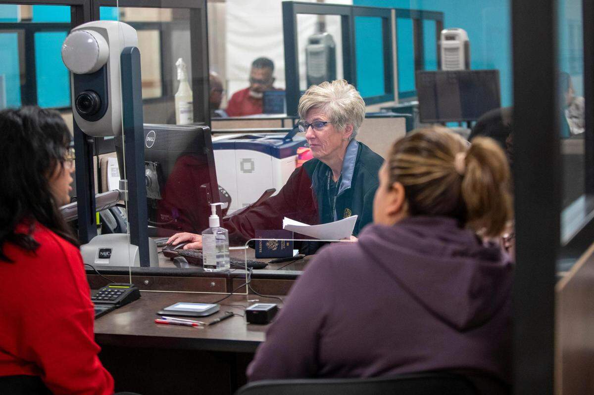 An employee helps customers at the Texas Department of Public Safety Driver License Mega Center in Fort Worth on Tuesday, Oct. 18, 2022.