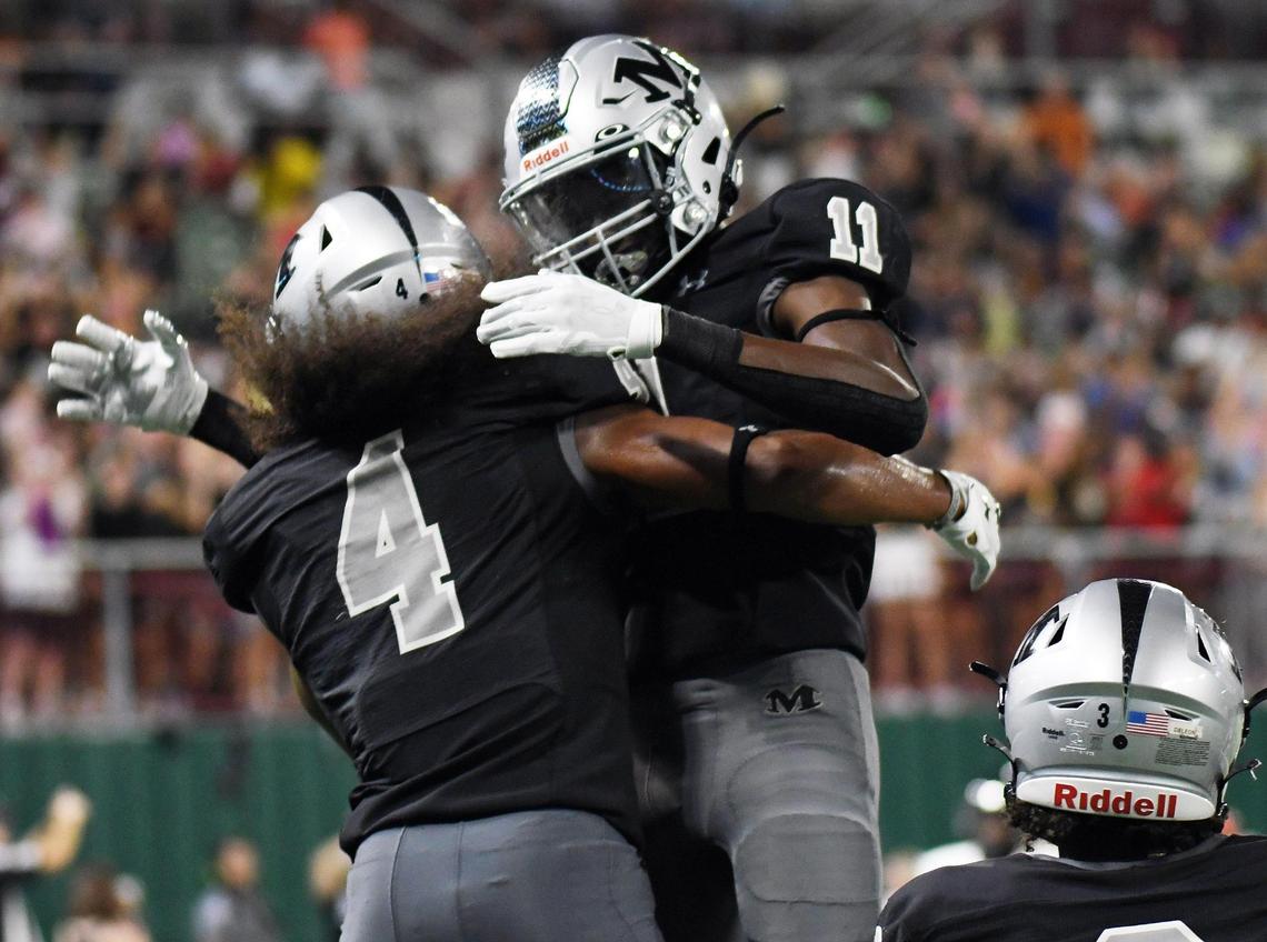 Arlington Martin’s Zaire Barrow, left, embraces teammate Jeremiah Charles after catching a 34 yard touchdown pass to give the Warriors a 32-17 lead over Lake Travis.
