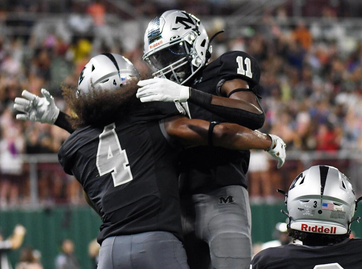 Arlington Martin’s Zaire Barrow, left, embraces teammate Jeremiah Charles after catching a 34 yard touchdown pass to give the Warriors a 32-17 lead over Lake Travis.