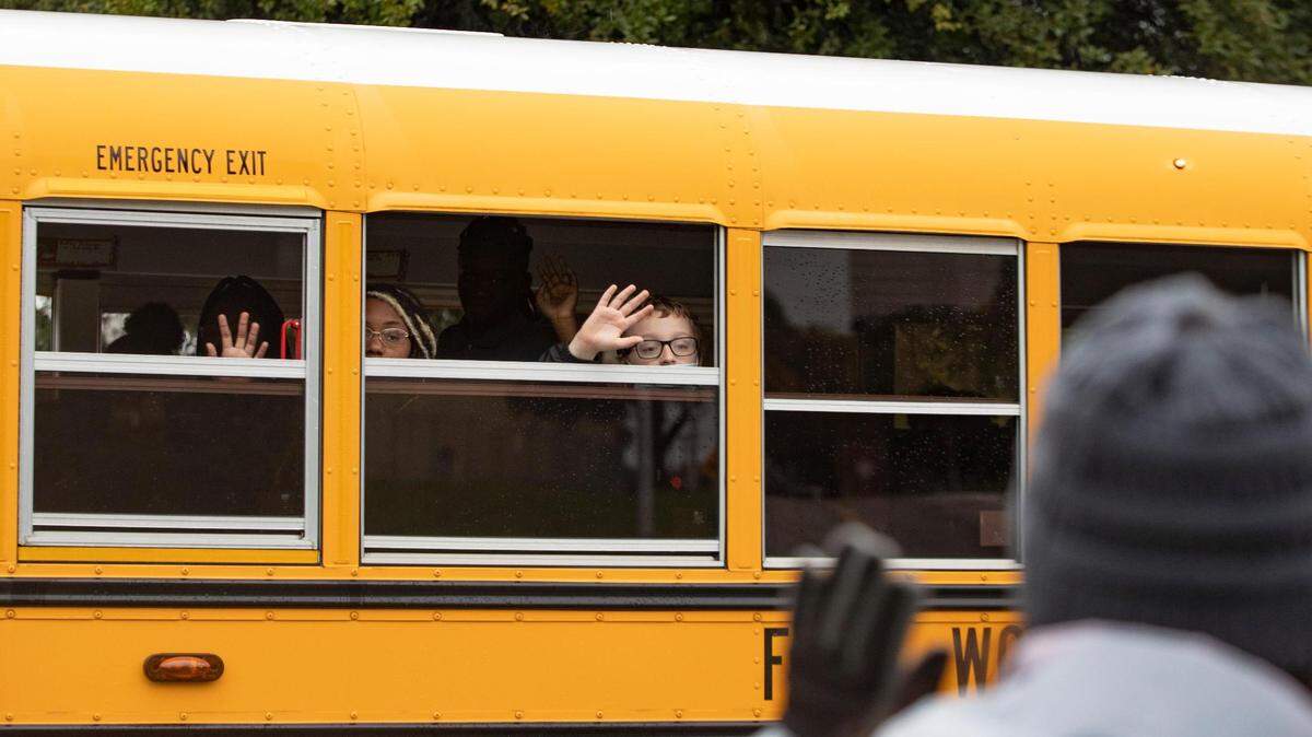 Fort Worth ISD students wave from a school bus during the Veterans Day Parade winding through Fort Worth on Nov. 11, 2022.