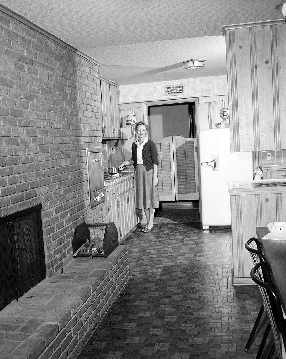 Nov. 19, 1958: Mrs. R.H. Talbert at the built-in electric range in her country kitchen.