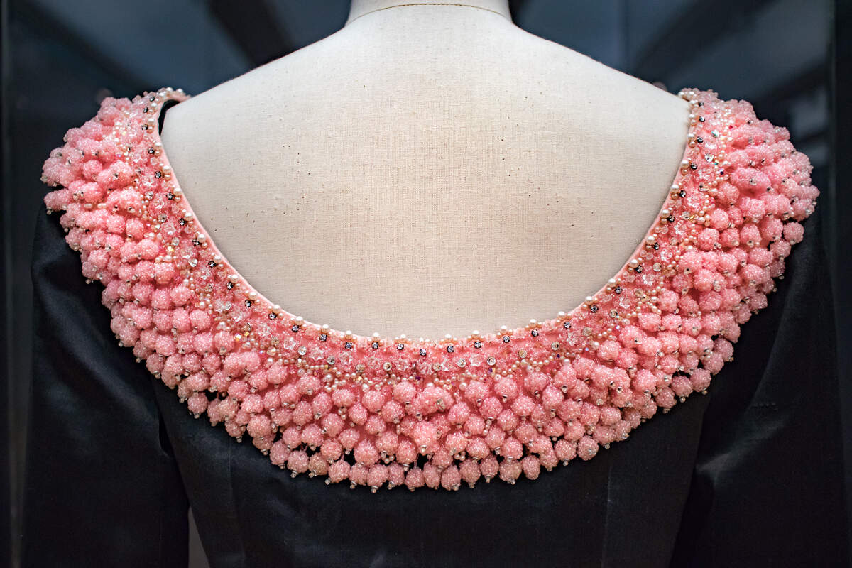 Cristóbal Balenciaga Dress detail of embroidery of tassels, pink costume beads and rhinestones, transparent beads on a pink satin background at the edge of the neckline.