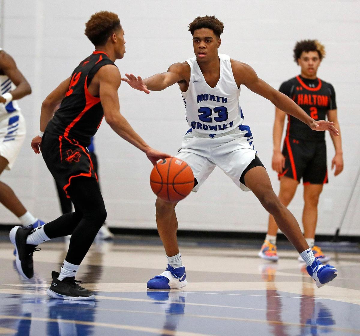 North Crowley forward Koreyan Davis (23) defends against Haltom guard Landon Scott (12) in a high school basketball game at North Crowley High School in Crowley, Texas, Tuesday, Jan. 19, 2021. North Crowley led 38-27 at the half. (Special to the Star-Telegram Bob Booth)