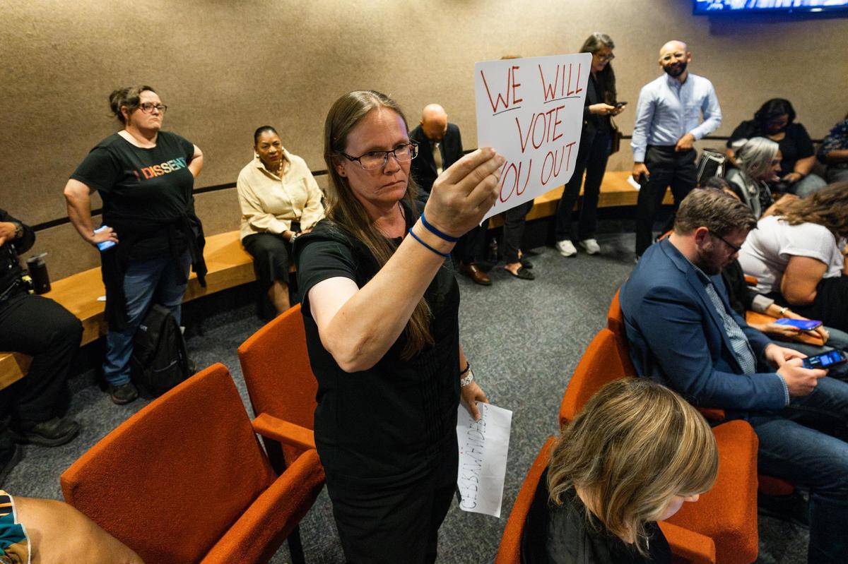 Fort Worth resident Crystal Betts holds a sign saying “We Will Vote You Out” after the Tarrant County Commissioners voted 3-2 to approve county-wide redistricting during a Tarrant County Commissioners Court meeting at the Tarrant County Administration Building in Fort Worth on Tuesday, June 3, 2025.