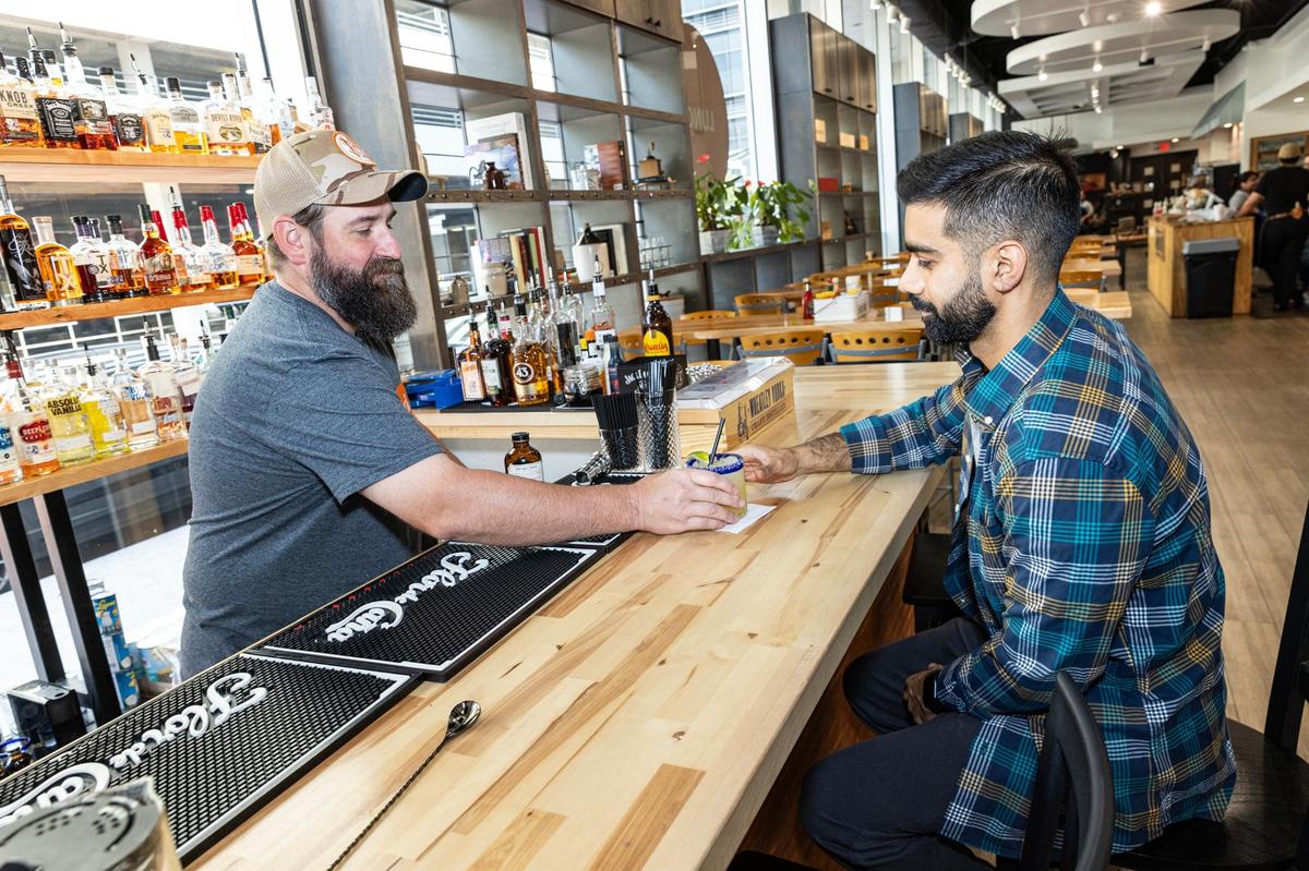 Bar manager Kevin Smith, left, serves customer Moez Faruqi a margarita at the bar in the Neighbors House restaurant in downtown Fort Worth on Thursday, Aug. 22, 2024.
