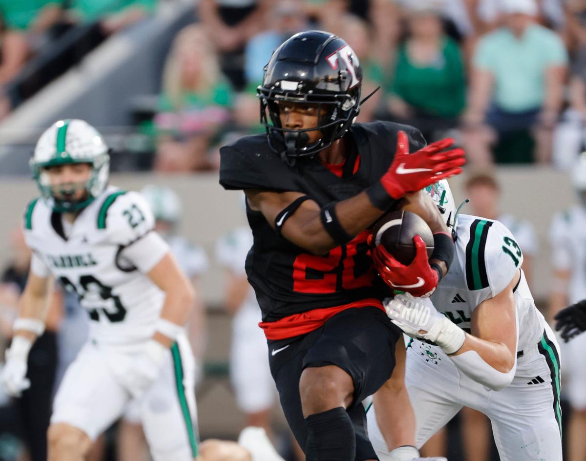 Trinity running back Joshua Bell (20) attempts to get away from Southlake defensive lineman Zac Hays (13) during a UIL 6A Conference football game at Pennington Field in Bedford Texas, Friday, Sept. 20, 2024.