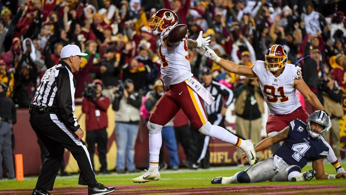 Washington Redskins linebacker Preston Smith, left, runs a fumble recovery into the end zone as Ryan Kerrigan and Dallas Cowboys quarterback Dak Prescott look on in the fourth quarter Sunday at FedEx Field. The touchdown gave the Redskins a 20-10 lead.
