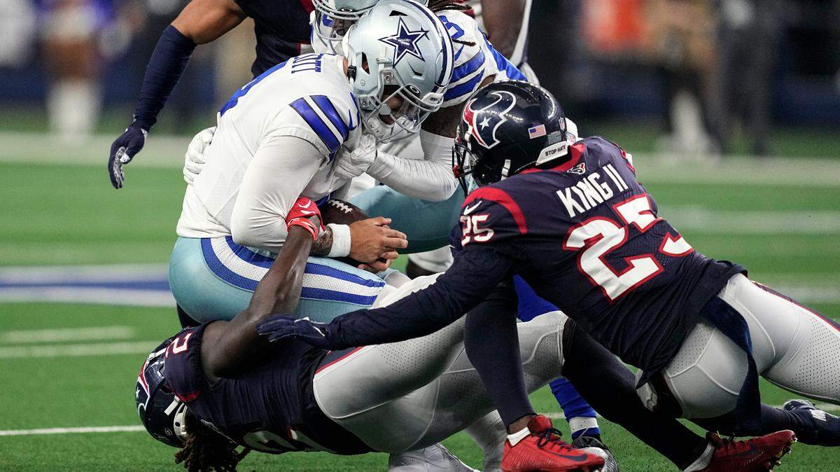 Dallas Cowboys quarterback Dak Prescott (4) is stopped by Houston Texans cornerbacks Tavierre Thomas (2) and Desmond King II (25) after running for a first down during Sunday’s game at AT&T Stadium.