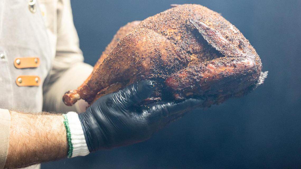 Brandon Hurtado pulls a turkey out of the smoker Monday, Oct. 31, 2022, at Hurtado Barbecue in Fort Worth.