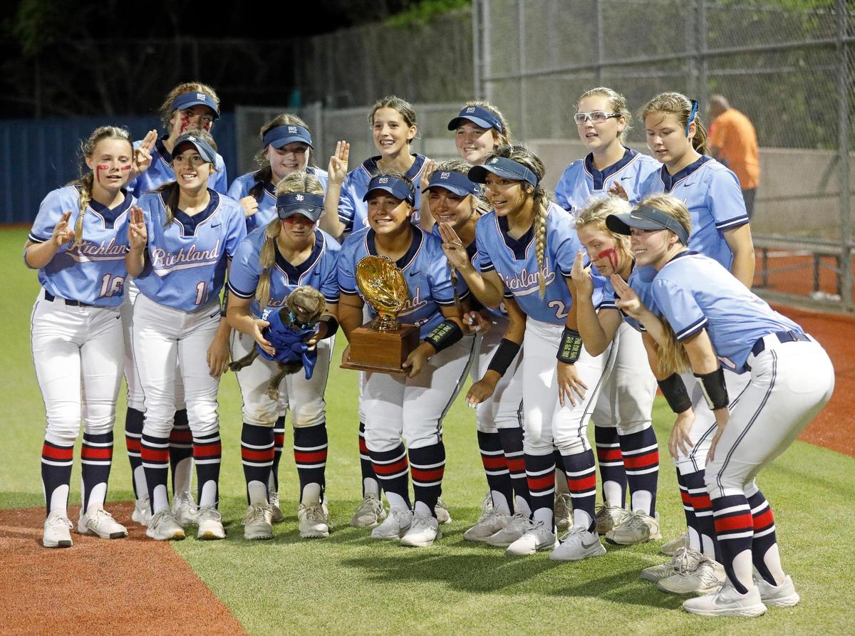 Richland Lady Royals pose with a past years trophy after winning a 5A Region I Bi-District softball playoff game at Brewer High School in White Settlement, Texas, Friday, April 30, 2022. Richland defeated Brewer 12-3 to move on to the next round. (Special to the Star-Telegram Bob Booth)