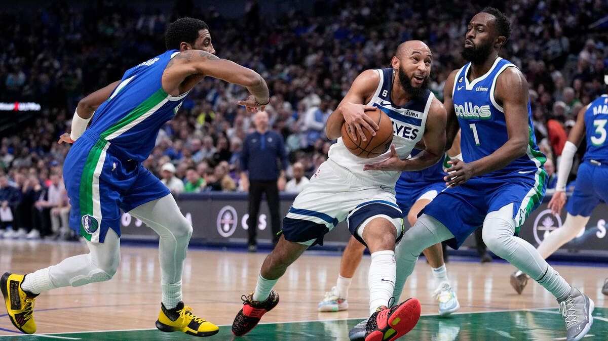 Minnesota Timberwolves guard Jordan McLaughlin, center, drives to the basket as Dallas Mavericks’ Kyrie Irving, left, and Theo Pinson (1) defend during their game on Monday at American Airlines Center.