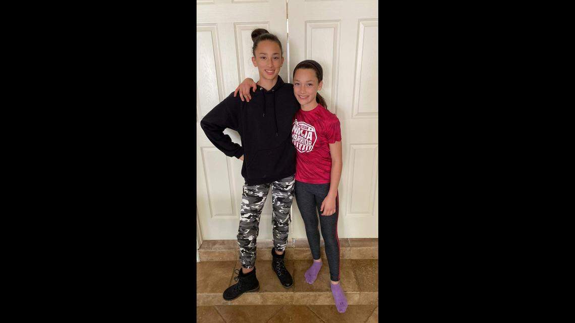 Tori, 11, right, with sister Carly, 13, of Southlake, needed rescue by the police and fire department Wednesday when she came across some rat snakes in a drainage pipe.