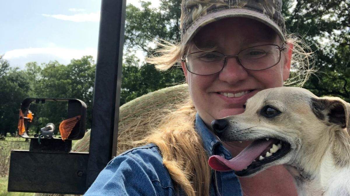 Cynthia N. Newton of Gustine, a social worker-farmer, atop a tractor with her dog, Rambeau.